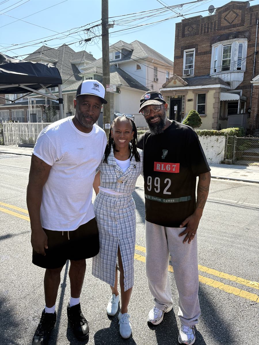 Lamont, a neighbour in a plaid dress and Prance standing together in the middle of the closed avenue
