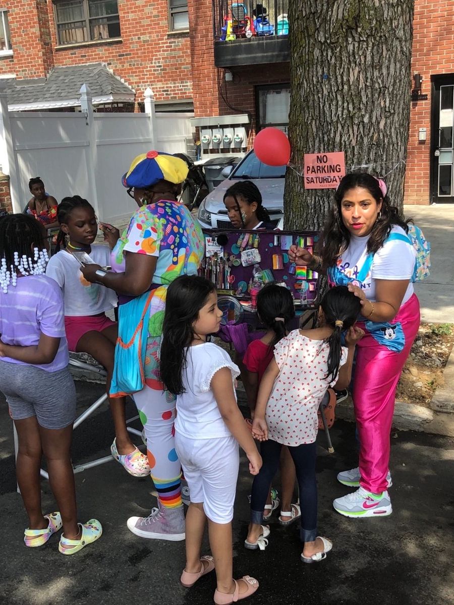 Kids lined up at the face painting station on the sidewalk