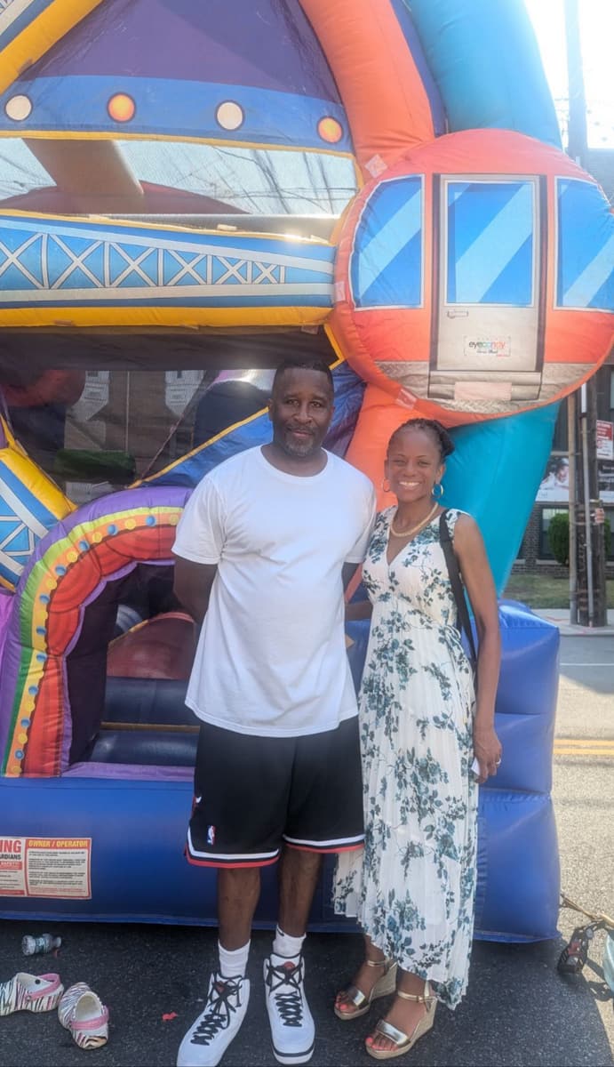 Two neighbors posing in front of the bouncy castle